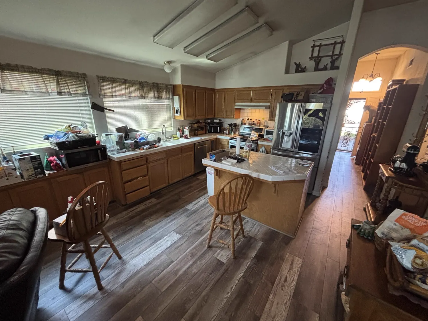 After: Kitchen floor replacement: damaged carpet torn out and replaced with wide-plank wood-look flooring throughout the kitchen and dining area.